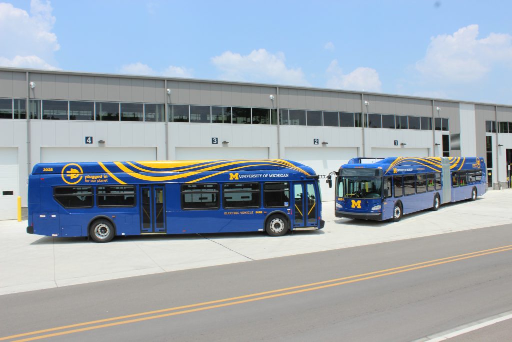 2 Electric Buses (One 40-ft and One 60-foot articulated) parked outside the new Dean Road Transportation Center on U-M's North Campus