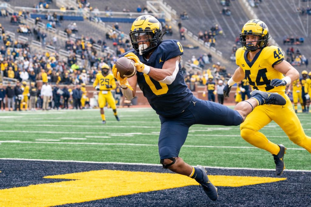 Michigan Football player diving into the end zone during a Maize and Blue scrimmage